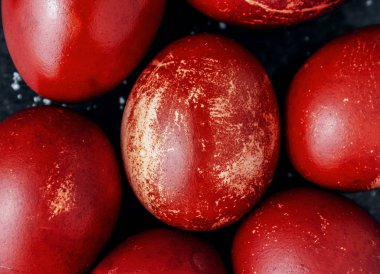 Tek renkli boyanmış Paskalya yumurtaları siyaha yakın, kırmızı tuğla renginde lekeler, çizikler, çizikler. El yapımı boyanmış yumurta. Düz yatıyordu