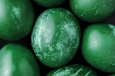 Tek renkli boyanmış paskalya yumurtaları koyu yeşil renkte, beyaz lekeli, çizikli, çizikli. El yapımı boyanmış yumurta. Düz yatıyordu