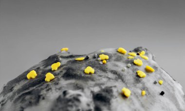 Şeker renkli konfeti, beyaz kremalı bir köy pastasının üzerinde uzanıyor. Kek yüzeyine şeker kreması dokusu yakın plan, pembe, mavi ve sarı şeker.