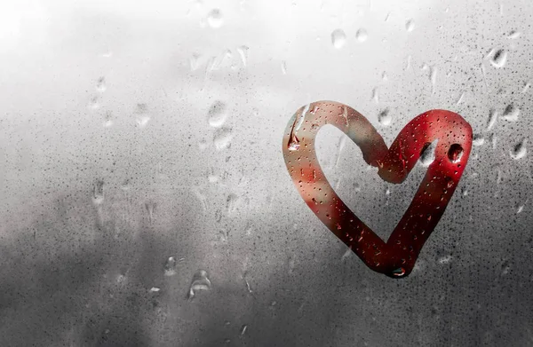 Coração vermelho pintado em vidro é embaçado e há muitas gotas sobre ele, conceito Dia dos Namorados — Fotografia de Stock
