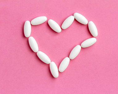 Terapi için verilen haplardan, tedavi konseptinden ve pembe üzerindeki sağlık hizmetlerinden oluşan kalp şekli