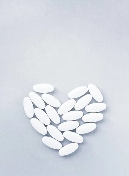 Tvar srdce z pilulek pro terapii, koncepce léčby a zdravotní péče na šedé — Stock fotografie