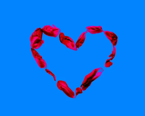 Серце червоних пелюсток ізольовано на синьому — стокове фото
