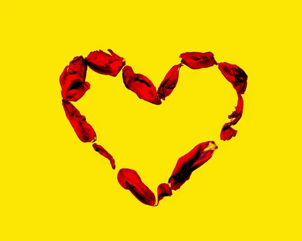 Corazón de los pétalos rojos aislados en amarillo — Foto de Stock