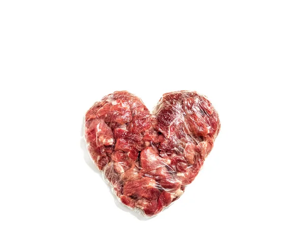 Carne fresca en forma de corazón sobre fondo blanco con película de alimentos, chuleta para chuletas —  Fotos de Stock