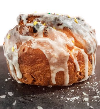 Kremalı rustik kahverengi bisküvi keki. Renkli pudralar ve şekerlerle kaplanmış beyaz lekeler akıyor. Buz kırıntıları ile siyah bir yüzey üzerinde durmak. Rus Paskalyasının sembolü. Paskalya kartı