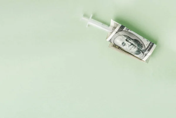 American money with syringe on green financial injection concept, the high cost of medical vaccines, flat lay — Stock Photo, Image