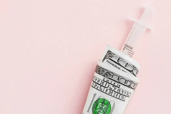 American money with syringe on pink financial injection concept, the high cost of medical vaccines, flat lay — Stock Photo, Image