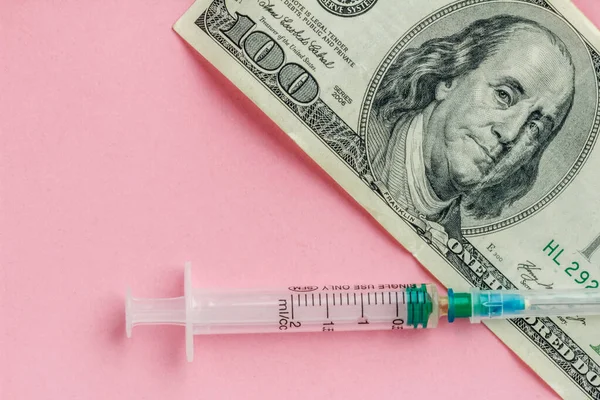 American dollar and empty syringe on pink background, vaccination concept, high cost of medical servicesy, flat lay — Stock Photo, Image