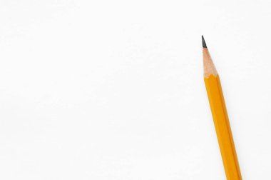 Beyaz arka planda izole edilmiş çapraz turuncu kalem, okula dönüş kavramı veya not kağıdı