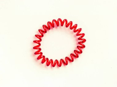 Beyaz arka planda saç için kırmızı spiral lastik bantlar.