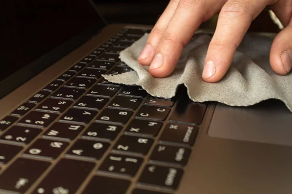 Disinfection and cleans the laptop keyboard with antibacterial wipes to protect from viruses, germs and bacteria during coronavirus outbreak flu covid ncov