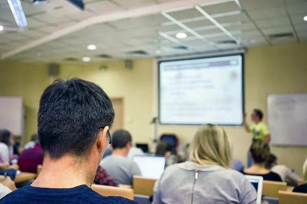 Rear view of students attentively listening to the teacher near the white board — Stock Photo, Image