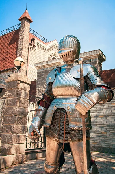 Mittelalterlicher Ritter in Kettenrüstung mit Schwert, mit abgesenktem Helm schützt die antike Burg. — Stockfoto