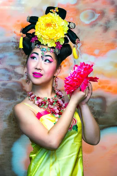 Retrato de niña hermosa china en vestido chino tradicional amarillo con flor — Foto de Stock
