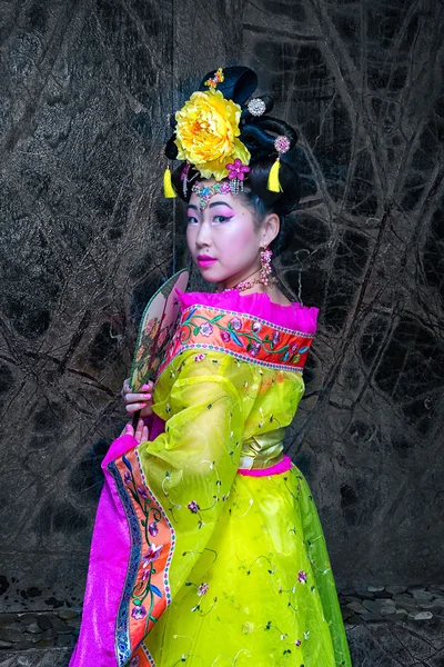 Азиатка с китайской традиционной одеждой чхонсам и с китайским веером в руках. Китайский новый год . — стоковое фото