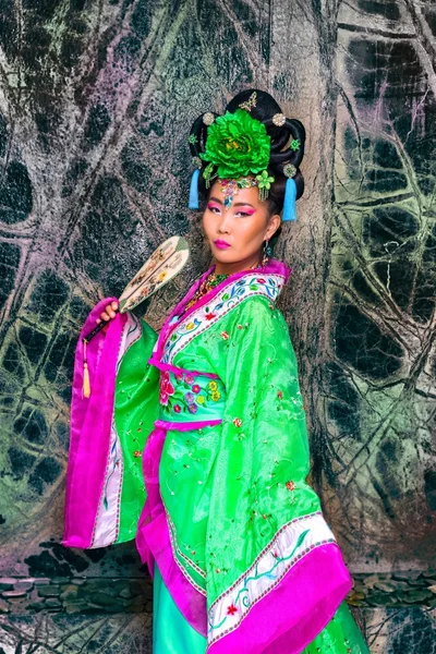 Aantrekkelijke Aziatische vrouw dragen chinese jurk houden van traditionele fan — Stockfoto