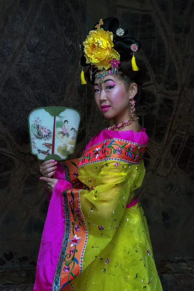 Aziatische vrouw met Chinese traditionele kleding cheongsam en bedrijf Chinese ventilator. Chinees Nieuwjaar concept. — Stockfoto