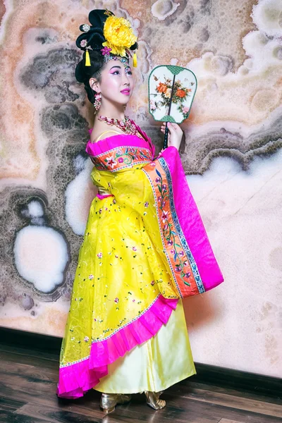 Hermosa mujer china con vestido amarillo tradicional con ventilador — Foto de Stock