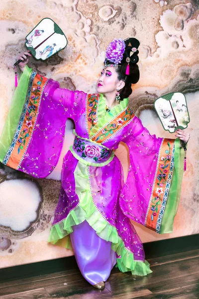 Wanita Cina cantik dengan gaun tradisional berdiri dengan penggemar melebarkan tangannya terpisah — Stok Foto