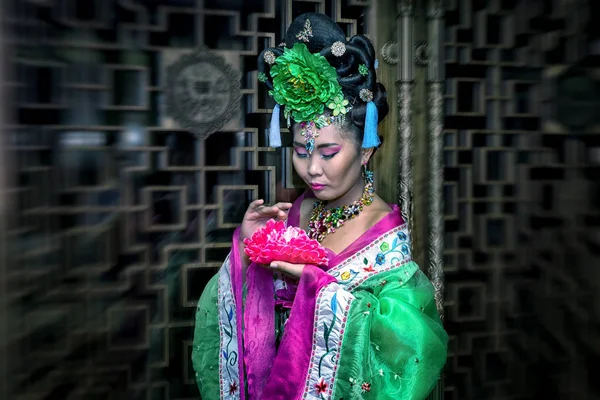 Kvinna i en traditionell kinesisk klänning med blomma, radiell oskärpa effekt — Stockfoto