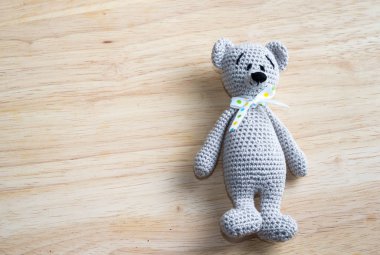 Amigurumi bebek ayı ahşap bir masa üzerinde kopya alanı ile