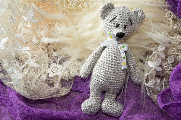 amigurumi crochet bear toy on the fur and rag with copy space for your inscription on a light fur.
