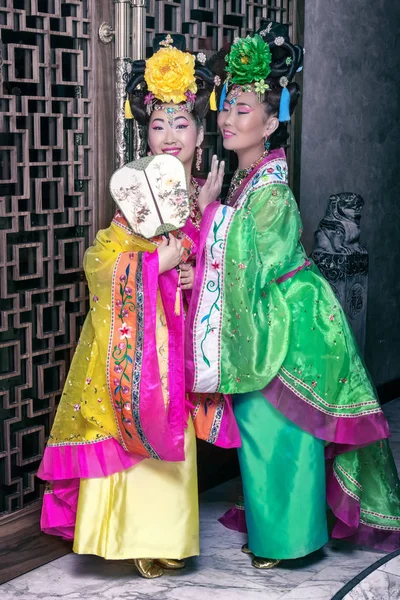 Δύο γκέισες ψιθυρίζοντας σε παραδοσιακή κινεζική εθνική φορέματα — Φωτογραφία Αρχείου