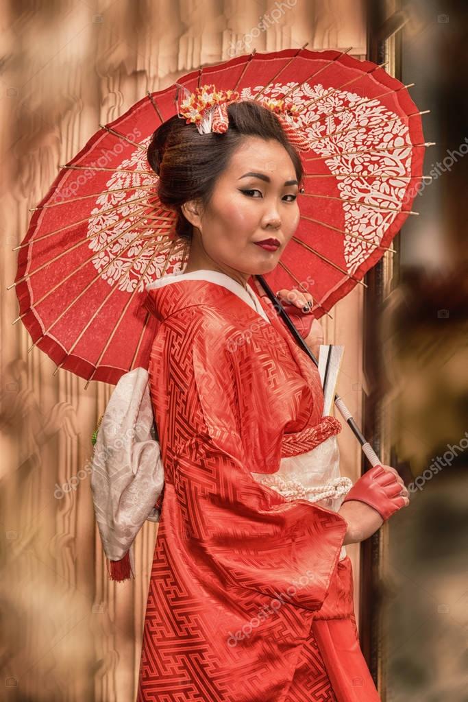 Jolie femme asiatique, vêtu d’un kimono japonais traditionnel et parapluie ...