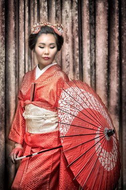 Asyalı kadın şemsiye ile geleneksel kırmızı kimono içinde