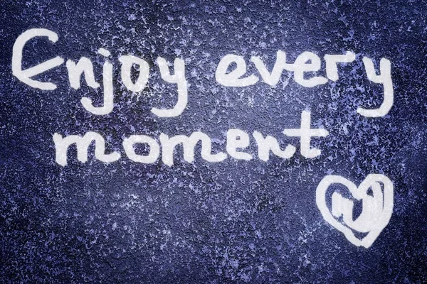 Enjoy every moment inscription and heart shape on the abstract grunge dark navy background — Stock Photo, Image