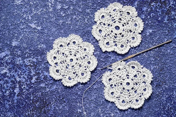 Tiga crochet doily dan kait pada latar belakang biru semen, ruang copy. cocok untuk latar belakang blog sulaman — Stok Foto