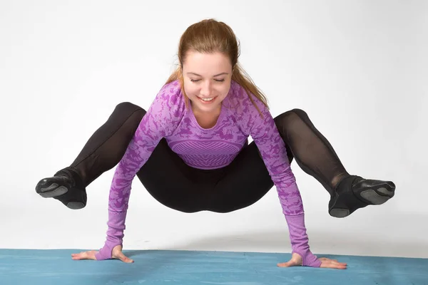 Deportiva feliz hermosa mujer joven practicando yoga, haciendo el brazo de pie, haciendo ejercicio con ropa deportiva negro y violeta, plano de estudio, longitud completa — Foto de Stock