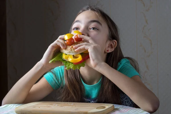 11 años chica con placer come una hamburguesa — Foto de Stock