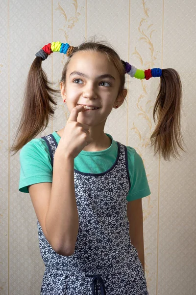 11-jarige meisje met pigtails als Pippi Longstocking met een ondeugende blik op haar gezicht en haar vinger naar haar mond zorgvuldig opzoeken. — Stockfoto