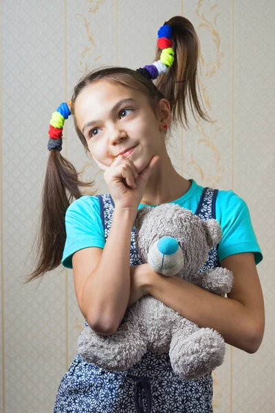 11 anos de idade menina com caudas engraçadas abraçando um ursinho de pelúcia — Fotografia de Stock