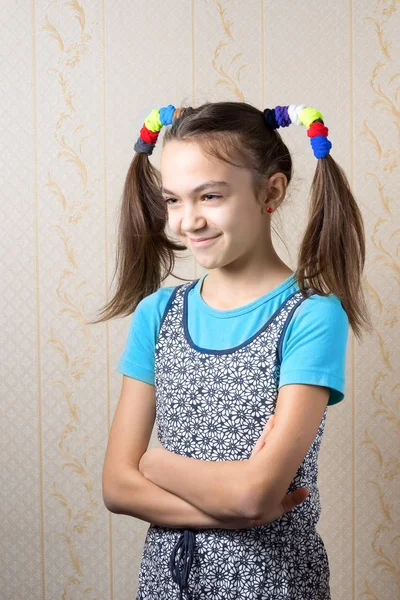 Portret uśmiechający się 11-letniej dziewczynki z śmieszne ogony w stylu Pippi Pończoszanka stojąc z rękami skrzyżowanymi. — Zdjęcie stockowe