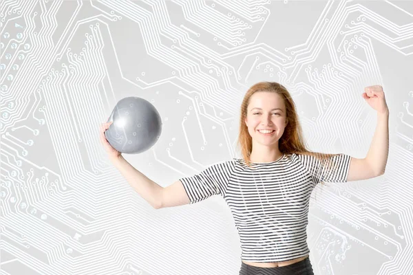 young woman athlete with strong biceps holding the ball in his hand on a computer circuit board background. Concept of education - a strong sports informatics.