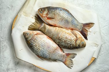 Kağıt, en iyi manzaralı bir kesme tahtası üzerinde üç taze sazan