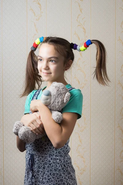 11 anos menina abraçando um ursinho de pelúcia — Fotografia de Stock