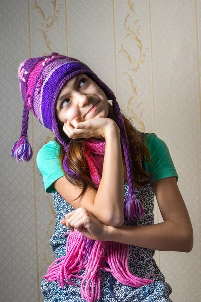 Retrato de uma menina de 11 anos de idade em uma camisa e um chapéu de malha e cachecol, olhando para cima pensivamente . — Fotografia de Stock