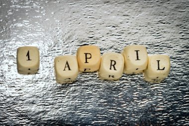 1 Nisan metin parlak Gümüş arka plan bir ahşap küplerin