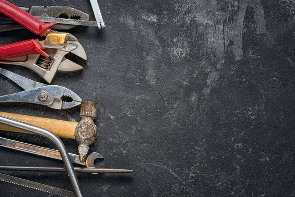 Ferramentas: chave, chave ajustável, serra, chave de fenda, martelo, serra no fundo de cimento preto com espaço de cópia . — Fotografia de Stock
