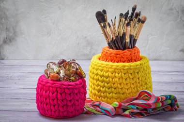 Colorful knitted baskets with brushes for make-up and feminine trifles clipart