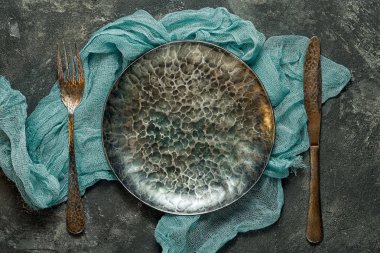 çatal bıçak takımı ile boş karanlık ortaçağ el yapımı dökme demir plaka üstten görünüm siyah çimento zemin üzerine