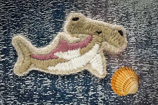 手工刺绣胸针形式锤鱼和海贝壳箔背景 — 图库照片