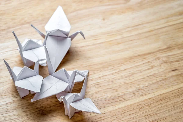 Grup Beyaz Kağıt kopya alanı ile ahşap bir masa üzerinde yapılan origami vinç — Stok fotoğraf