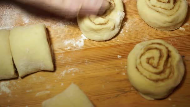 Cocinar rollos de canela. masa cruda, cortada en anillos, formada en bollos . — Vídeo de stock