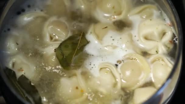 Traditional Russian food is dumplings. Cooking process. Pelmeni are cooked in boiling water with a bay leaf and black peppercorns. — Stock Video