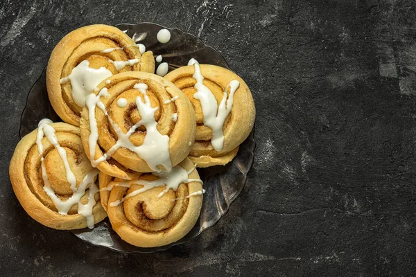 Cinnamon rolls on a plate on the dark cement background witn copy space — Stock Photo, Image